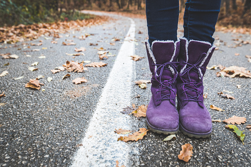 Close up of a purple hiking boots on an empty road