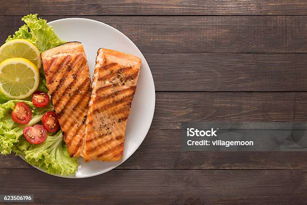 Grilled Salmon With Lemon Tomato On The Wooden Background Stock Photo - Download Image Now