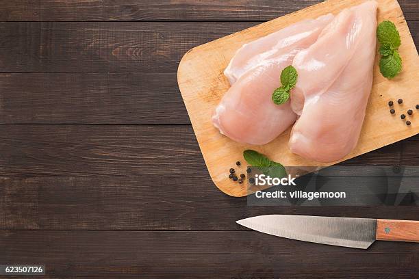 Top View Raw Chicken On Cutting Board On Wooden Stock Photo - Download Image Now - Raw Food, Chicken Breast, Chicken Meat