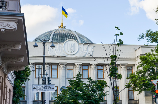 Kiev, USA - May 25, 2013: Ukrainian parliament building called Verhovna Rada with Ukrainian flag on dome and street sign