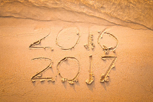 istock Happy New Year 2017 text on the sea beach. 623509720