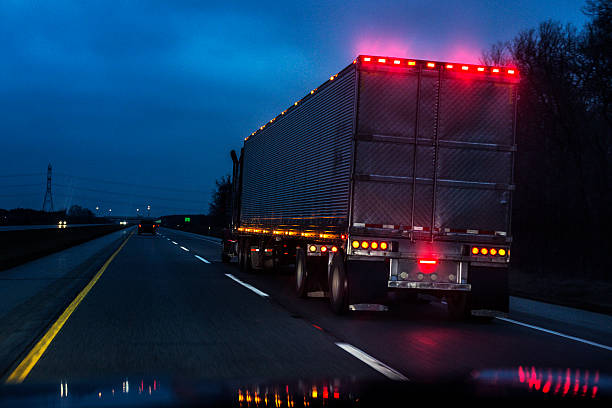 expressway speeding car driver pov passing illuminated semi trailer truck - vehicle trailer flash photos et images de collection