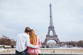 romantic couple looking at Eiffel tower in Paris
