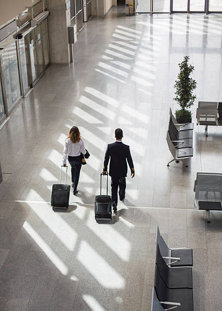 空港ターミナルを歩く船長とパイロット - cabin crew pilot airport walking ストックフォトと画像