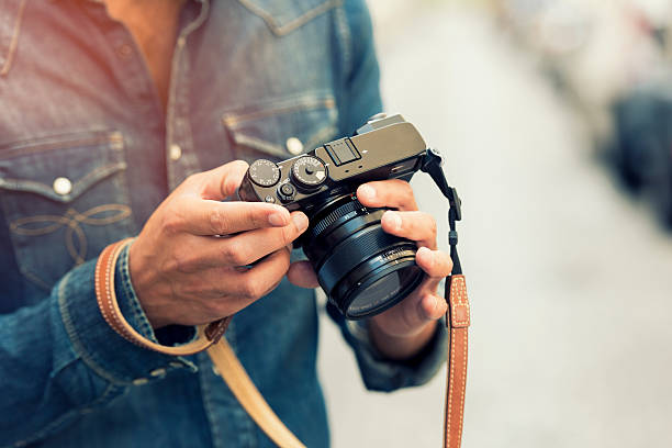 photographer makes its settings. background street. lens flare - reportage photographer photographing street imagens e fotografias de stock