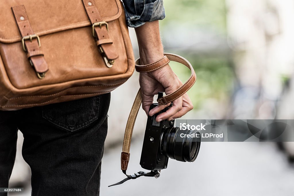 Photographer with leather bag in the city Urban man photographer with leather bag in the city. Close-up hands Photographer Stock Photo