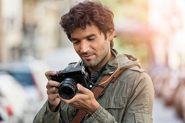 cheerful photographer in the street - reportage photographer photographing street imagens e fotografias de stock