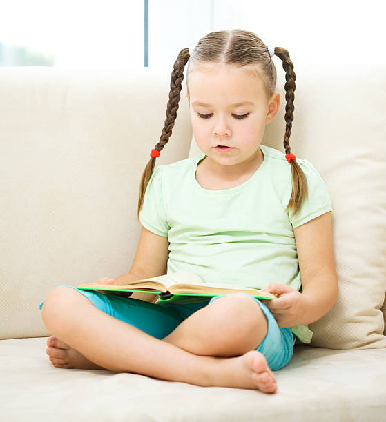 istock Little girl reads a book 623518686