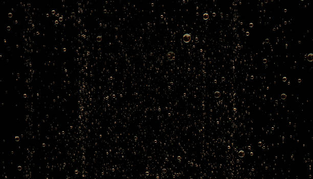 Golden Colored Sparkling Champagne Bubbles on Black Background High quality 3D render of golden colored sparkling champagne bubbles. Champagne bubles are moving on a black background. Horizontal composition with copy space. Luxury concept. Great use as a background for christmas, wedding and celebration related concepts. carbonated stock pictures, royalty-free photos & images