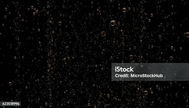 Golden Colored Sparkling Champagne Bubbles On Black Background Stock Photo - Download Image Now