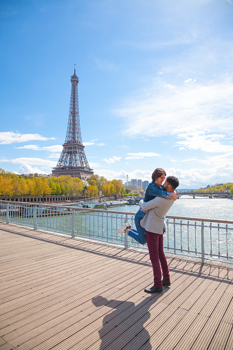 mixed race couple in love by sunny eiffel tower