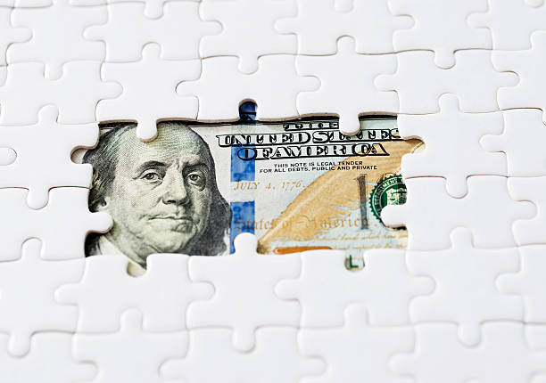 istock US paper currency with jigsaw puzzle 623524430
