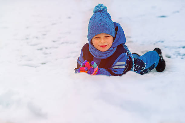 istock happy little boy having fun in winter snow 623528036