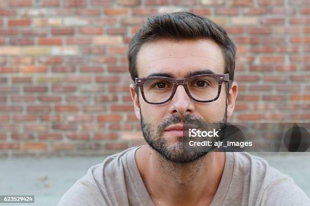 Joven Atractivo Hombre Mirando A La Cámara Foto de stock y más banco de imágenes de Hombres - Hombres, Gente común y corriente, Cara humana