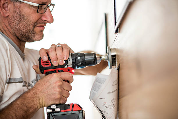 Handyman at work Closeup photo of a handyman using a drilling machine holding drill stock pictures, royalty-free photos & images