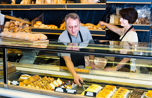 istock male staff offering fresh pastry 623533588