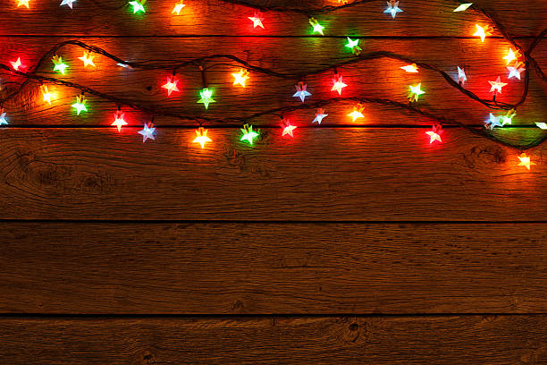 istock christmas lights border on wood background 623534516