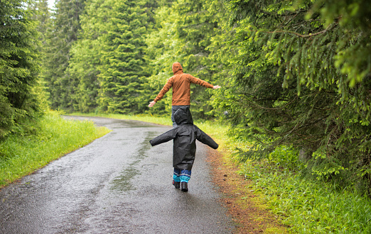 Father and his daughter stepping and playing on aeroplane into a puddle during rainy, Czech republic
