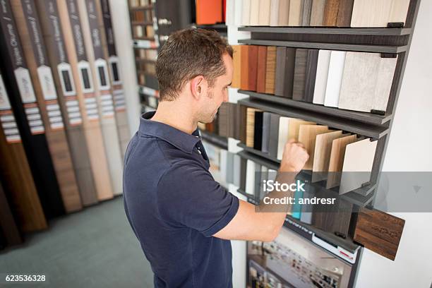 Man At A Floor Store Looking At Wood Samples Stock Photo - Download Image Now - Flooring, Shopping, Wood - Material