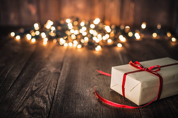 istock Christmas Gift on Old Plank and defocused lights 623537776