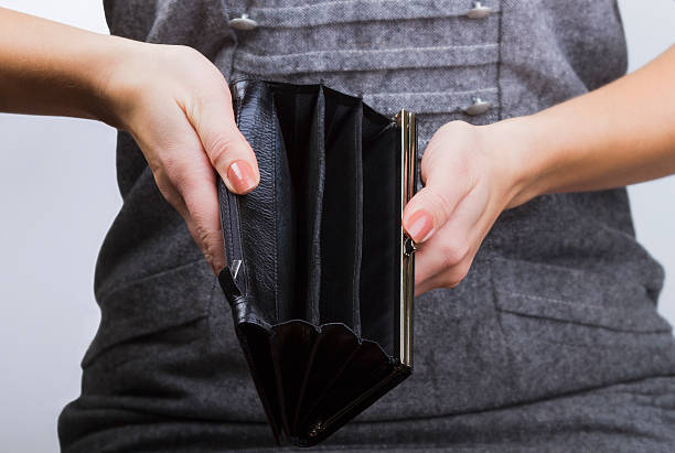 istock Female hands holding empty black purse, grey background 623538396