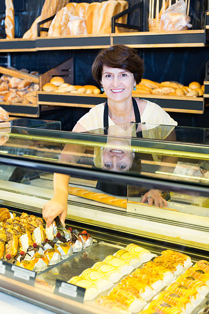 istock female baker offering fresh pastry 623539002