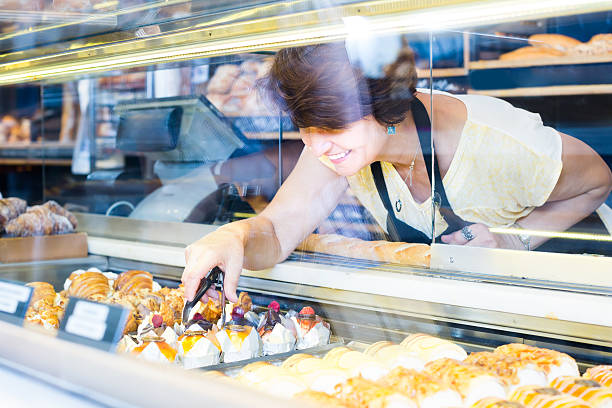 istock female baker offering fresh pastry 623539046