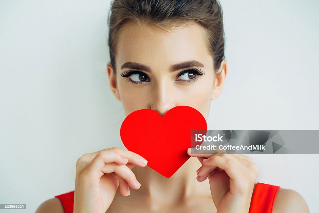 Beautiful girl holding artificial heart Studio shot of young beautiful woman holding artificial heart. Professional make-up. Valentine's Day - Holiday Stock Photo