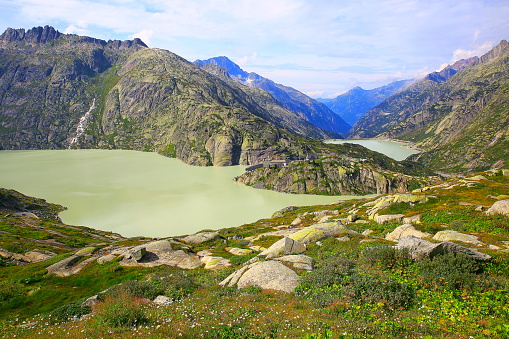 Grimsel pass summit alpine landscape, glacier lake reservoir, Road crossing swiss alps