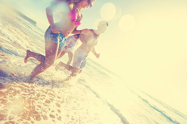 istock Smiling young people running on the beach 623586988