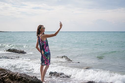 woman making  selfie on sea coast with sunglasses