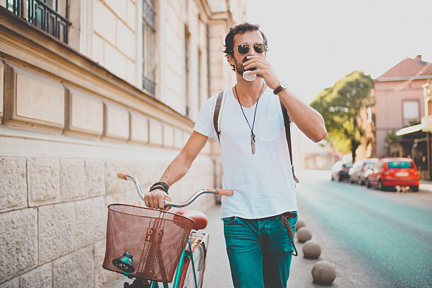 ein fahrrad schieben und kaffee trinken - man walking bike stock-fotos und bilder
