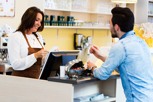 istock Cute young waitress  by the cash register making bill 623588962