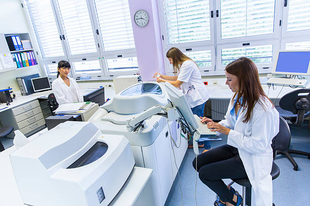 three cute technicians in laboratory of blood bank - bloedbank stockfoto's en -beelden