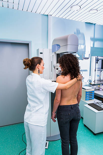 Nurse with young women having a mammography Nurse with young women having a mammography x ray image medical occupation technician nurse stock pictures, royalty-free photos & images