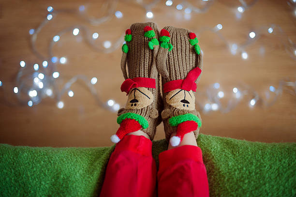 istock Legs in socks near Christmas garland 623589900