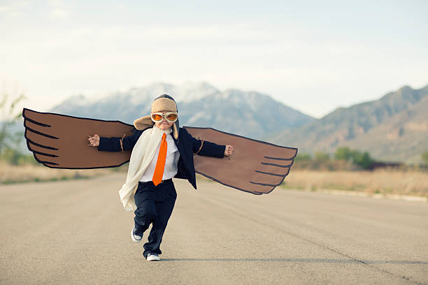 garoto empresário vestido de terno com asas de papelão - pre flight - fotografias e filmes do acervo