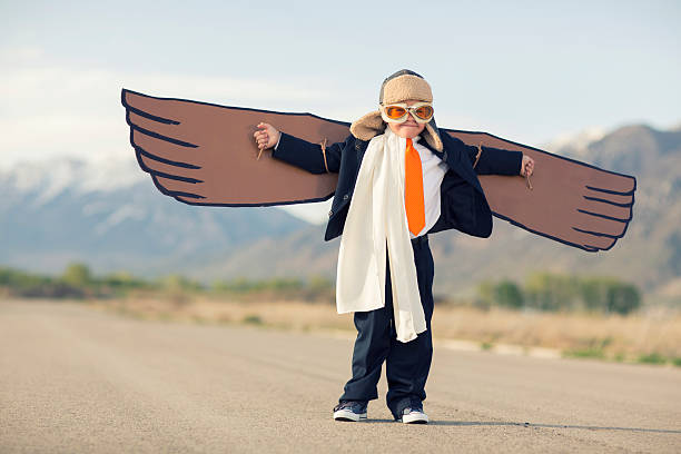 istock Young Boy Businessman Dressed in Suit with Cardboard Wings 623590730