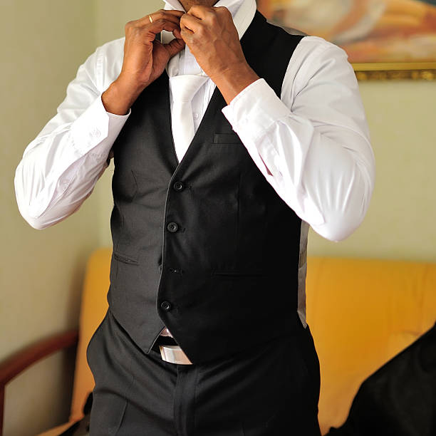 Young man with Down syndrome gets ready for his prom night at home. He is getting dressed, excited for the big night ahead.