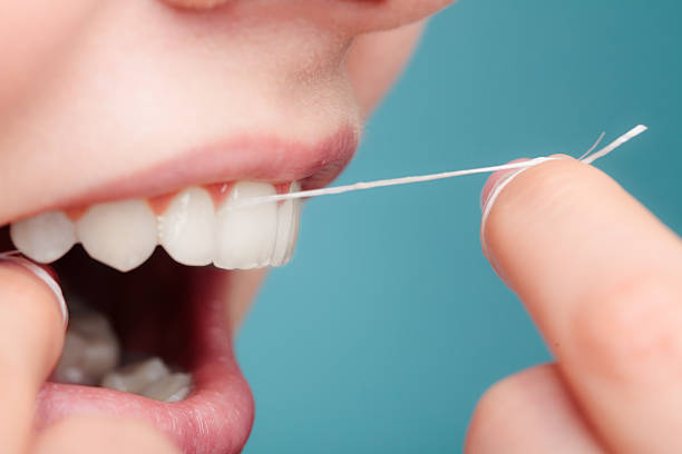 istock side view woman face smiling with dental floss. 623595828
