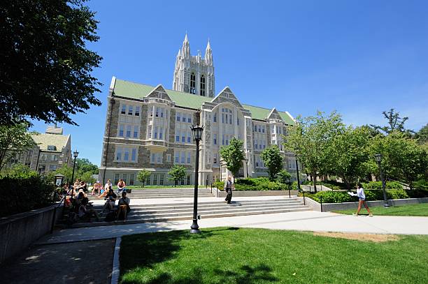 Students at Boston College Chestnut Hill, Massachusetts, USA - July 21, 2016: Students resting on O'Neill Plaza in front of Gasson Hall on the campus of Boston College in Chestnut Hill, Massachusetts. boston college campus stock pictures, royalty-free photos & images