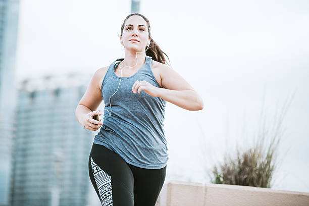 woman running in downtown austin - body positive imagens e fotografias de stock