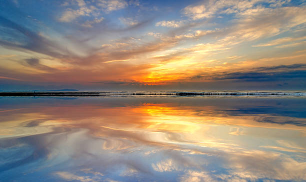 istock beach mirrors the sky at sunrise time 623596882
