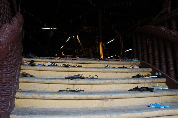 Angkor Wat, Cambodia - October 23th, 2016: some paired shoes and flip flops have been left on the steps of the main access of some Cambodian Buddist temple in the surroundings of Angkor Wat.