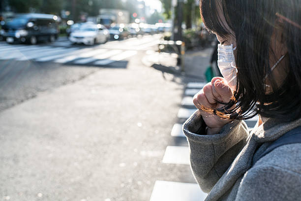 woman with a mask coughing - illness mask pollution car imagens e fotografias de stock