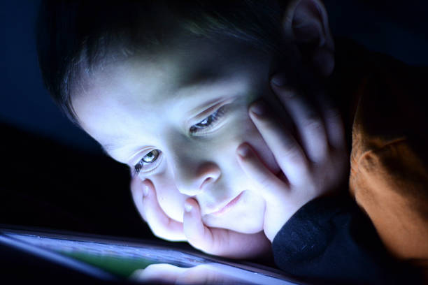 istock Little Boy Watching A Tablet Close to His Face 623603302