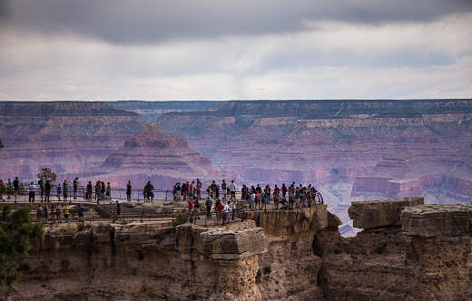 Tourists at the Grand Canyon looking over the rails at Mather Point.