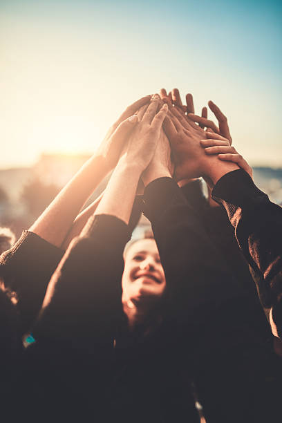 grupo de adolescentes voluntarios con las manos levantadas al cielo - teen activity fotografías e imágenes de stock