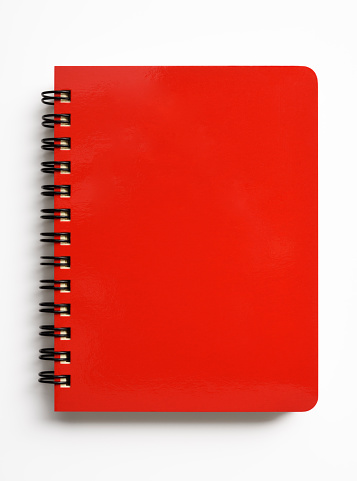 Overhead shot of closed red spiral notebook isolated on white background with clipping path.