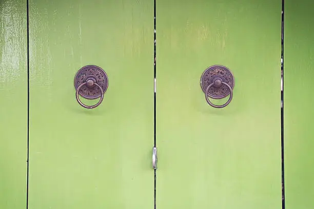 green door with circle iron door-handle